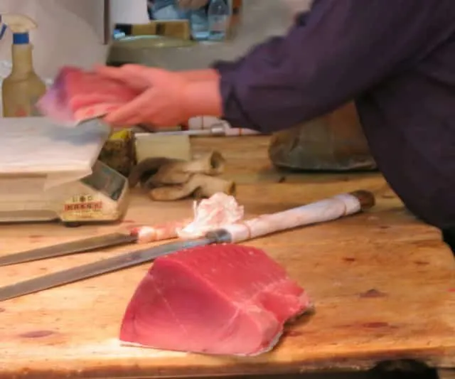 Butchers Portion out Fresh Tuna at Tsukiji Market in Tokyo Japan