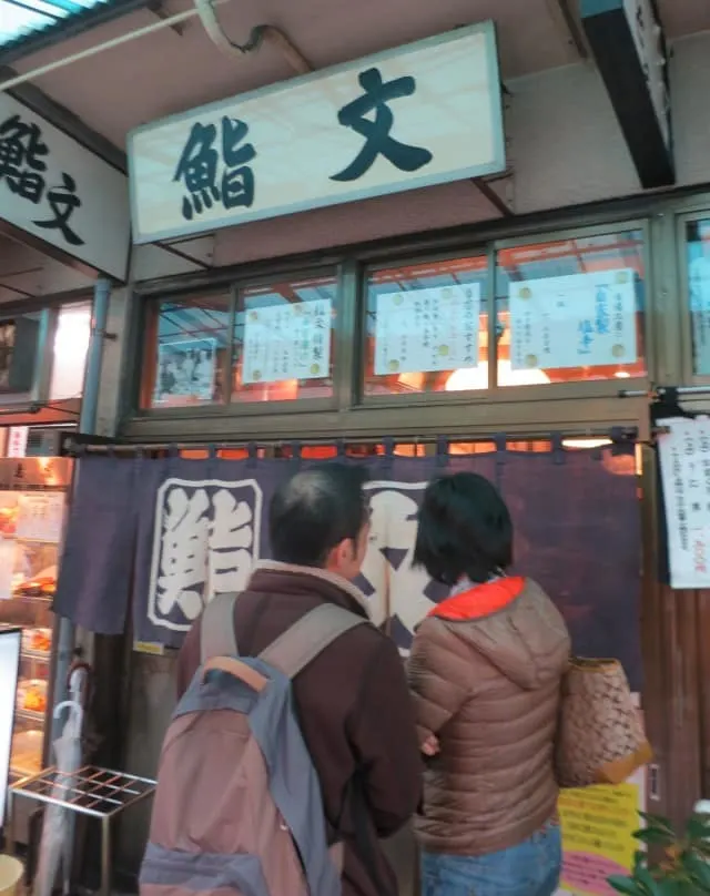 Customer line up outside Sushi Bun at Tsukiji Market in Tokyo Japan