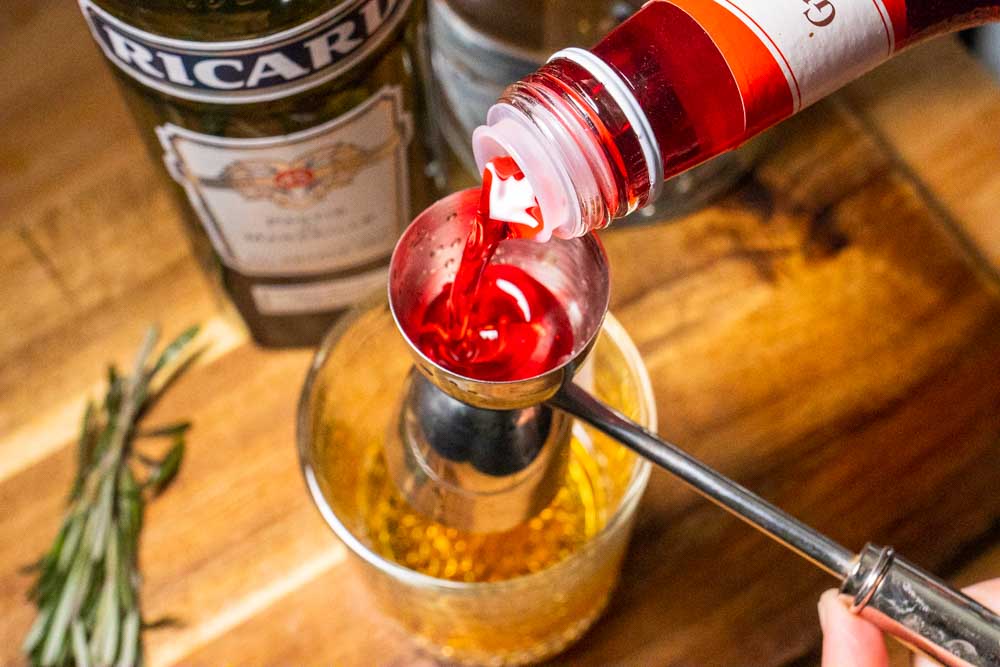 Pouring Grenadine into Tomate Cocktail