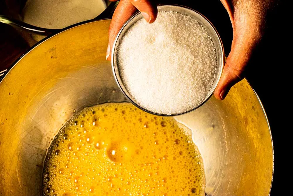 Pouring Sugar into Bourbon Eggnog Mixture