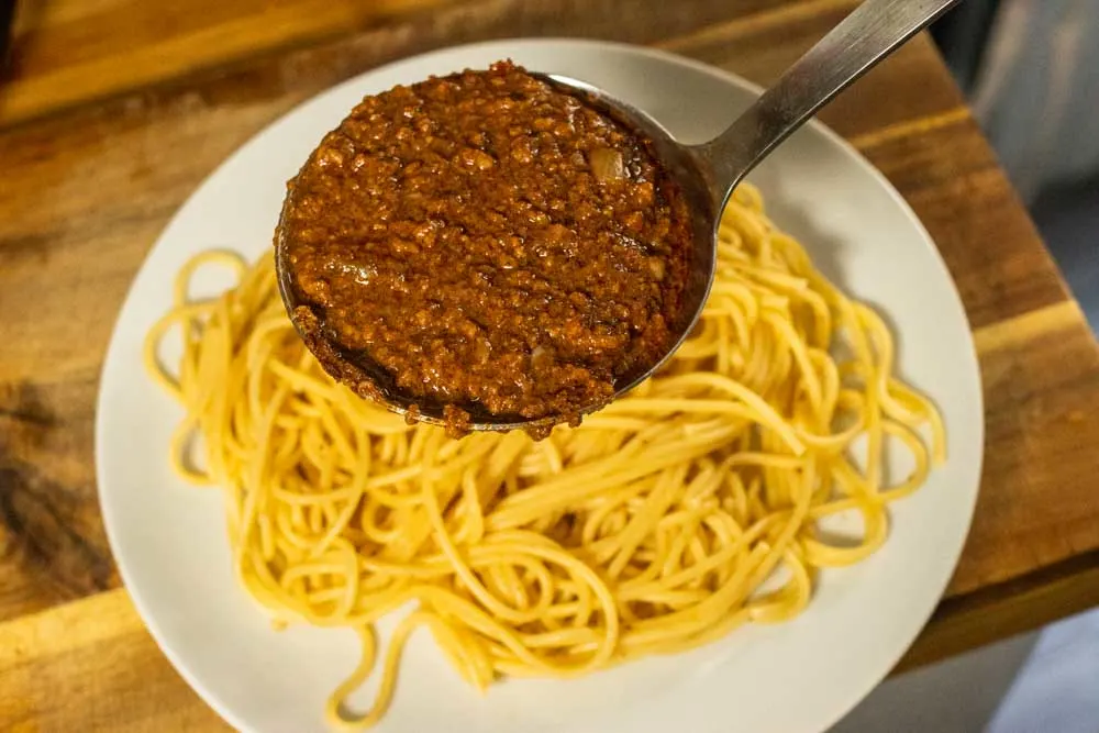 Ladeling Cincinnati Chili on Spaghetti