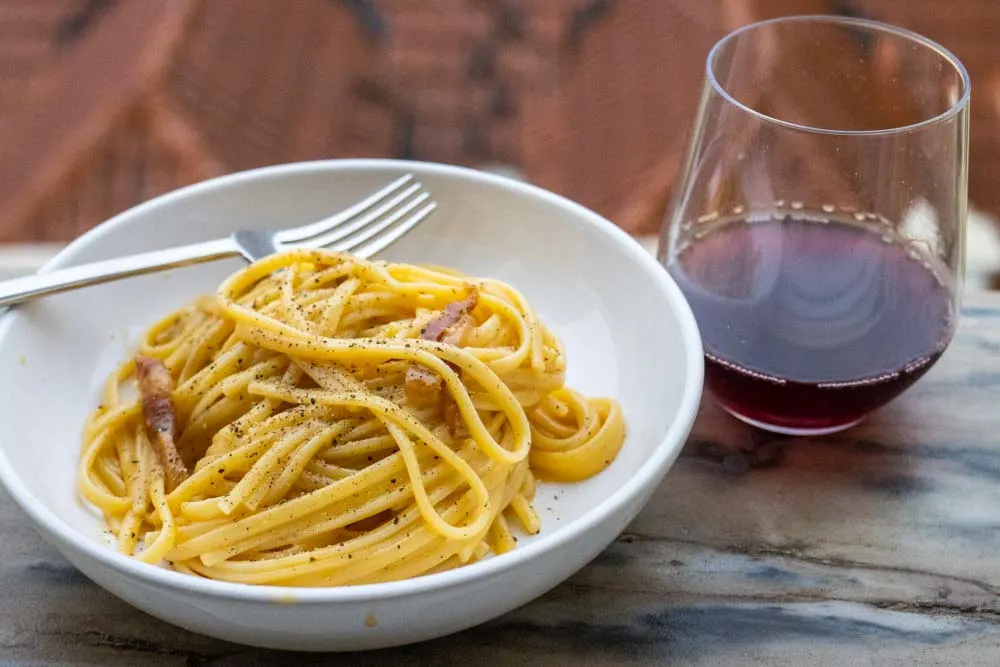 Bowl of Carbonara with Red Wine on Ledge