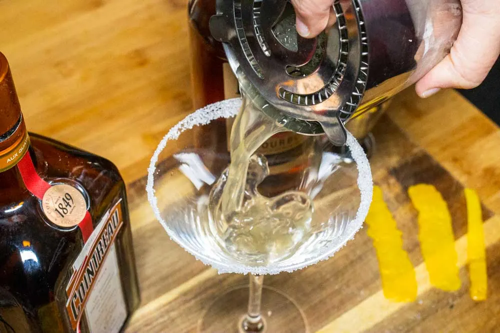 Straining Bourbon Sidecar into Glass