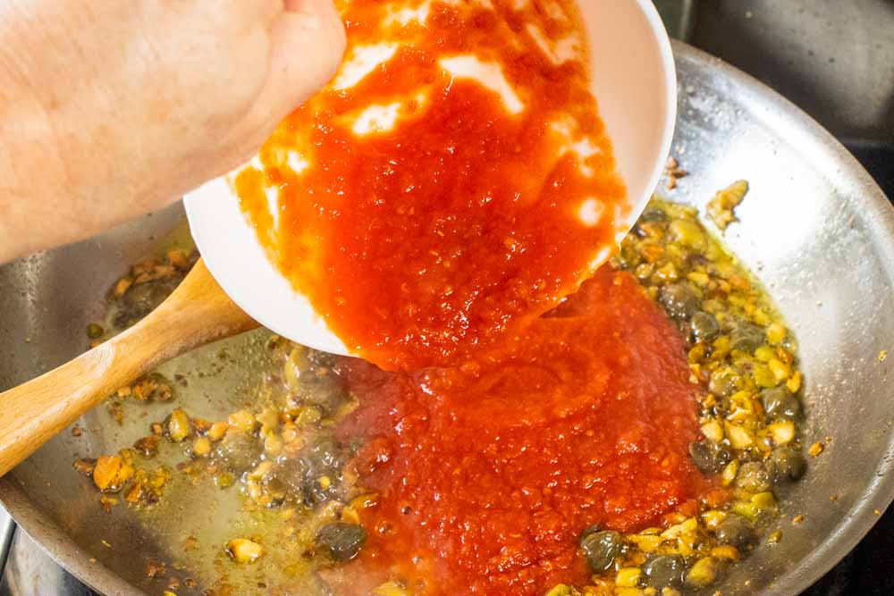 Pouring Spaghetti alla Puttanesca Sauce