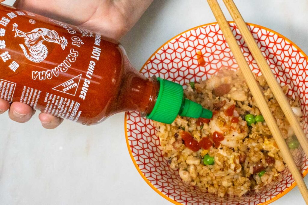 Squeezing Sriracha on Yangzhou Fried Rice