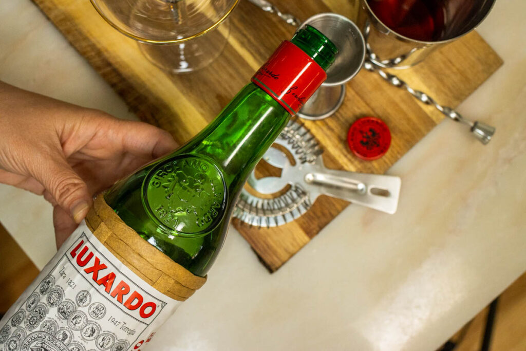 Measuring Maraschino Liqueur into Diplomat Cocktail