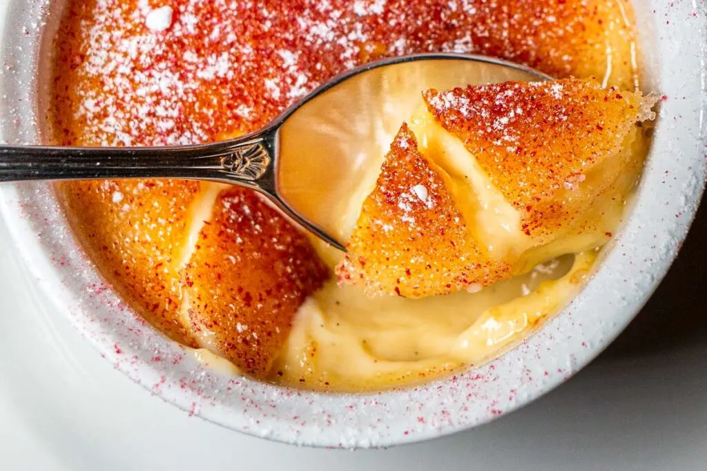 Creme brulee with a spoon shattering the surface