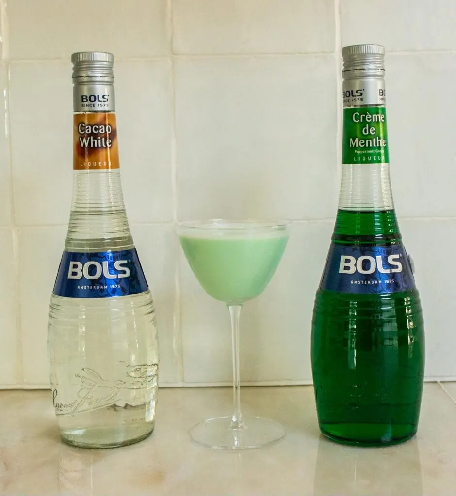 Grasshopper Cocktail Next to Liqueur Bottles