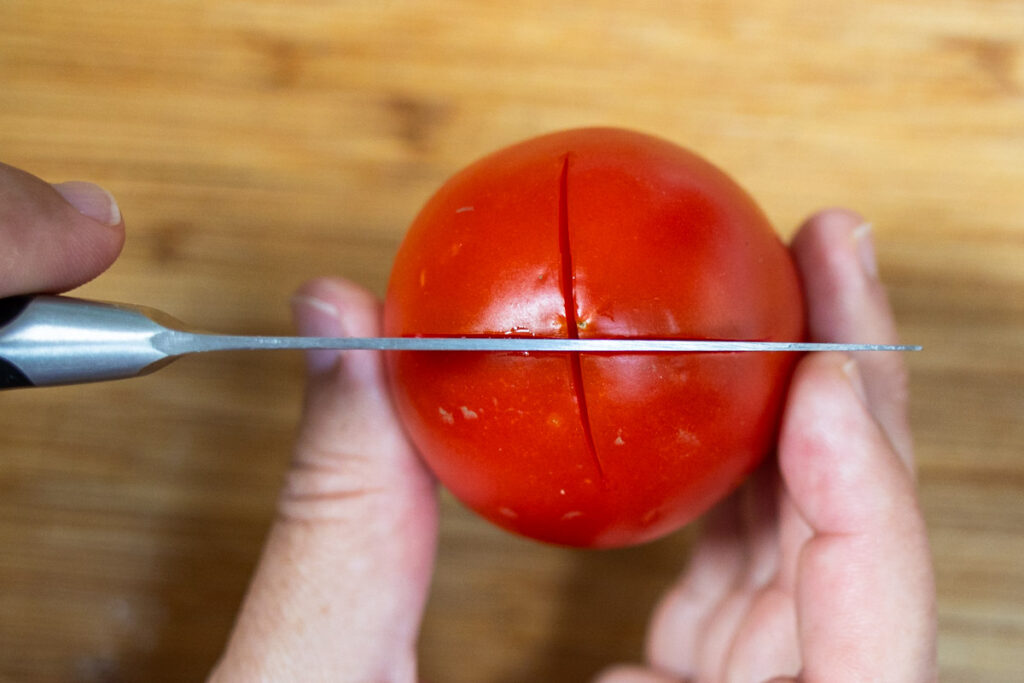 Cutting a tomato before blanching it
