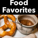 Pinterest image: photo of a pretzel, wurst and mustard on plate with caption reading "German Food Favorites"