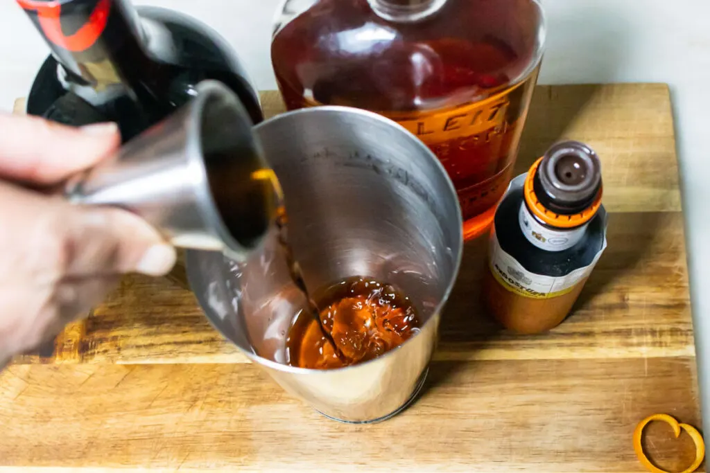 Pouring Bourbon into Revolver Cocktail Recipe