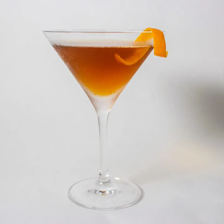 Revolver Cocktail with Orange Twist and White Background
