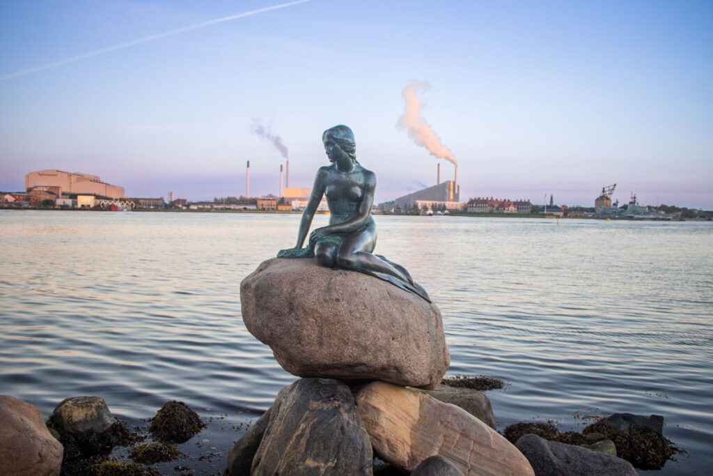 Little Mermaid Statue with Smoke Stacks in Copenhagen