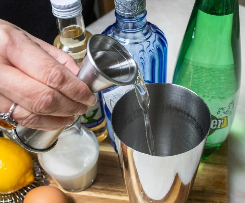 Pouring Gin into Ramos Gin Fizz Cocktail