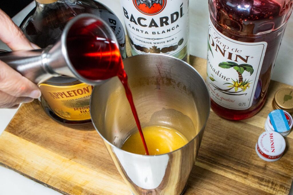 Pouring Grenadine into Shaker for Hurricane Cocktail Recipe