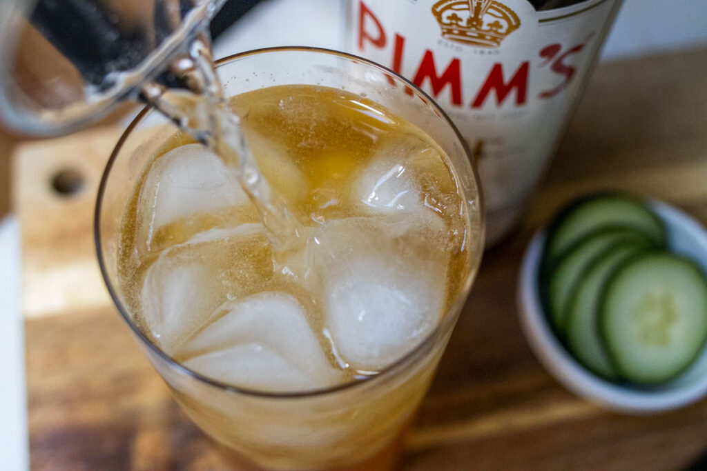 Pouring Soda into Pimms Cup Cocktail from Above