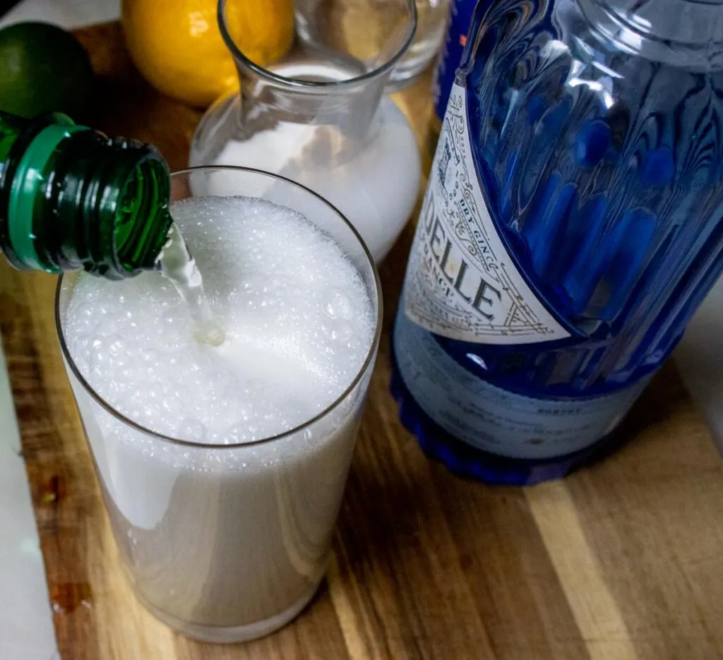 Pouring Sparkling Water into Ramos Gin Fizz Cocktail