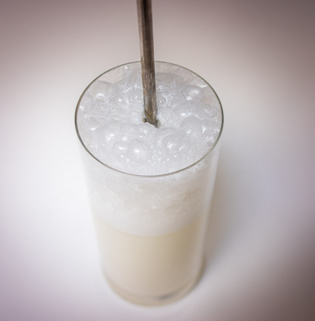 Ramos Gin Fizz Cocktail from Above with Straw and White Background