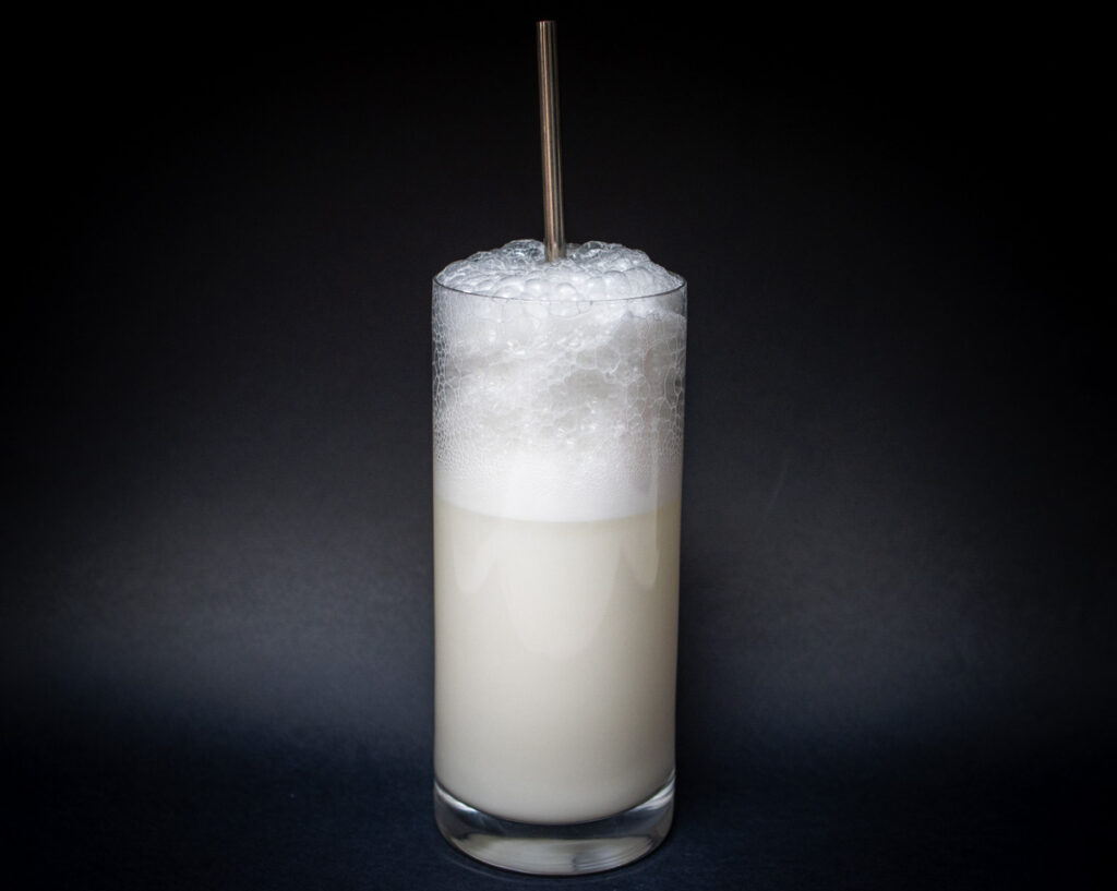 Ramos Gin Fizz Cocktail with Straw and Black Background