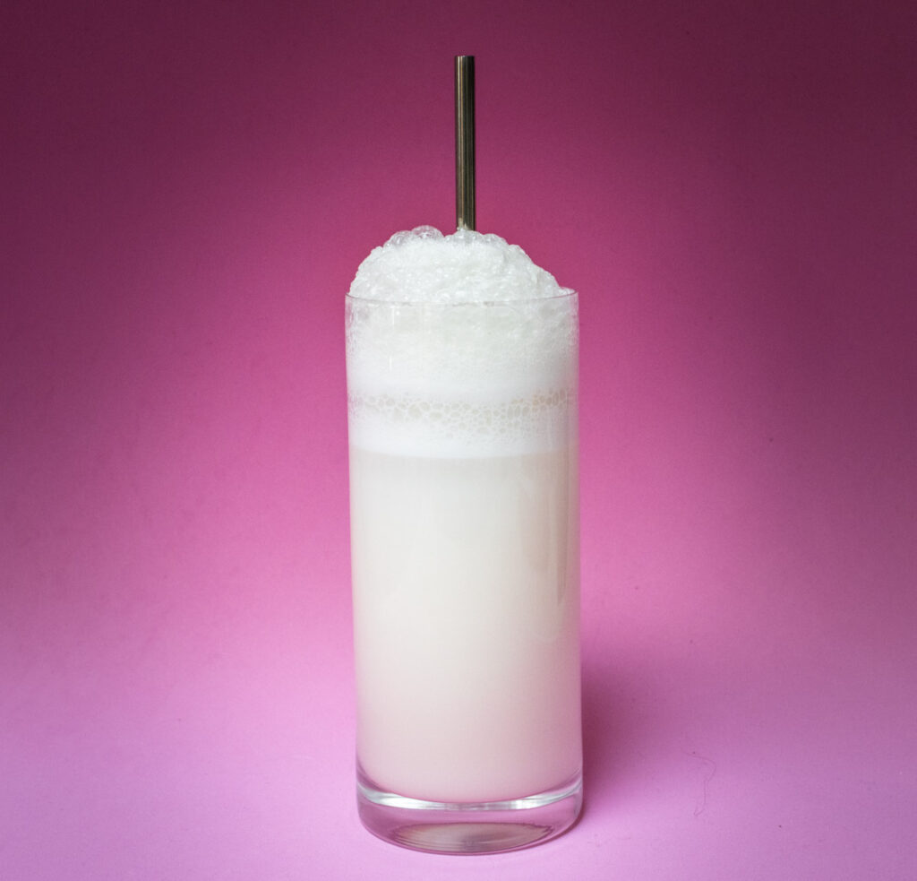Ramos Gin Fizz Cocktail with Straw and Pink Background