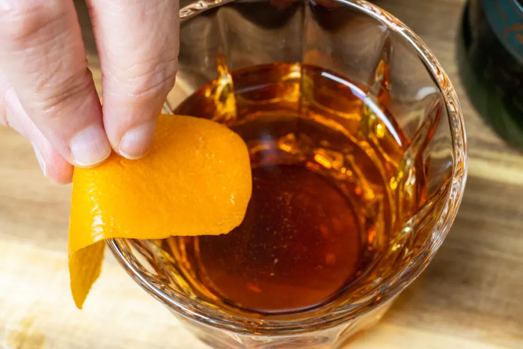 Expressing Orange Peel for an Emerald Cocktail