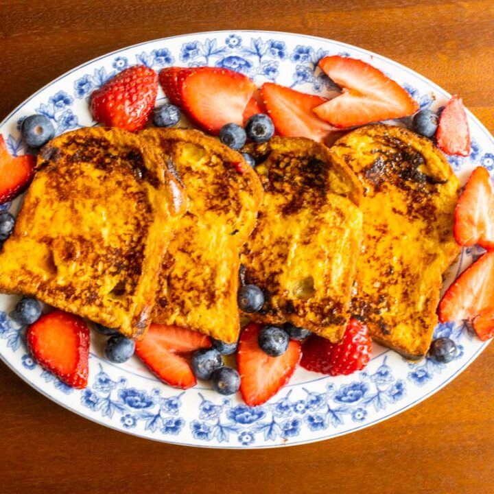 French toast with strawberries and bananas on an oval plate