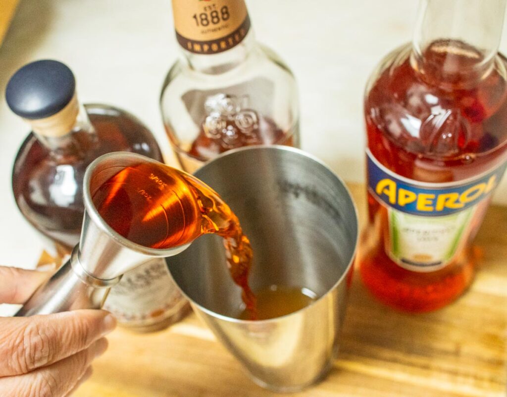 Pouring Aperol into Paper Plane Cocktail