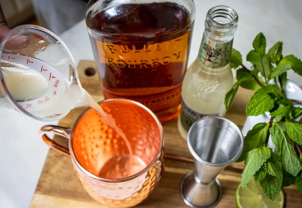 Pouring Lime Juice for Kentucky Mule Recipe