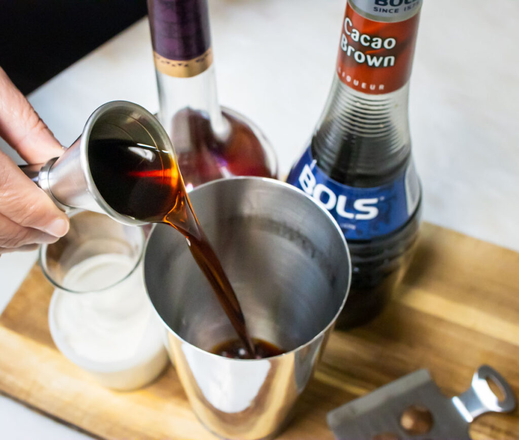 Pouring Liquor into a Brandy Alexander Recipe