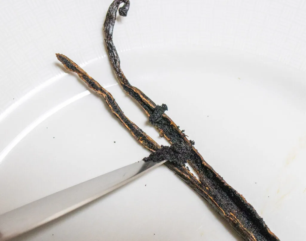 Scraping a vanilla bean with a paring knife