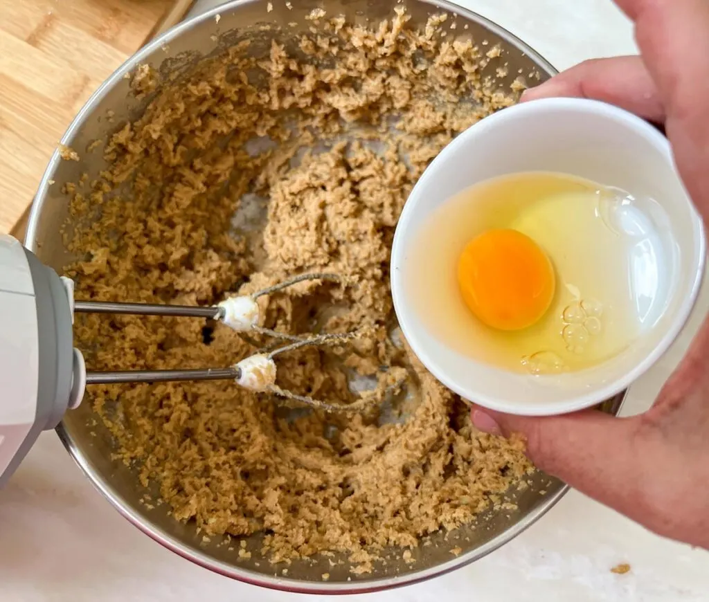 Adding eggs to creamed butter and sugar