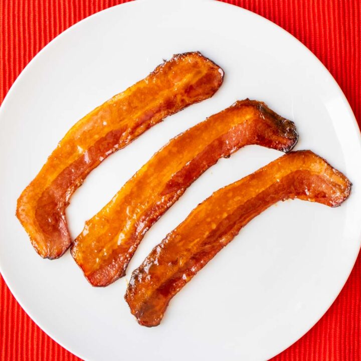 Maple bacon on a plate with a red background