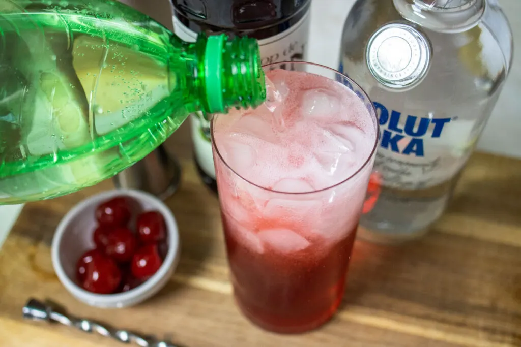 Pouring Soda into a Dirty Shirley Cocktail