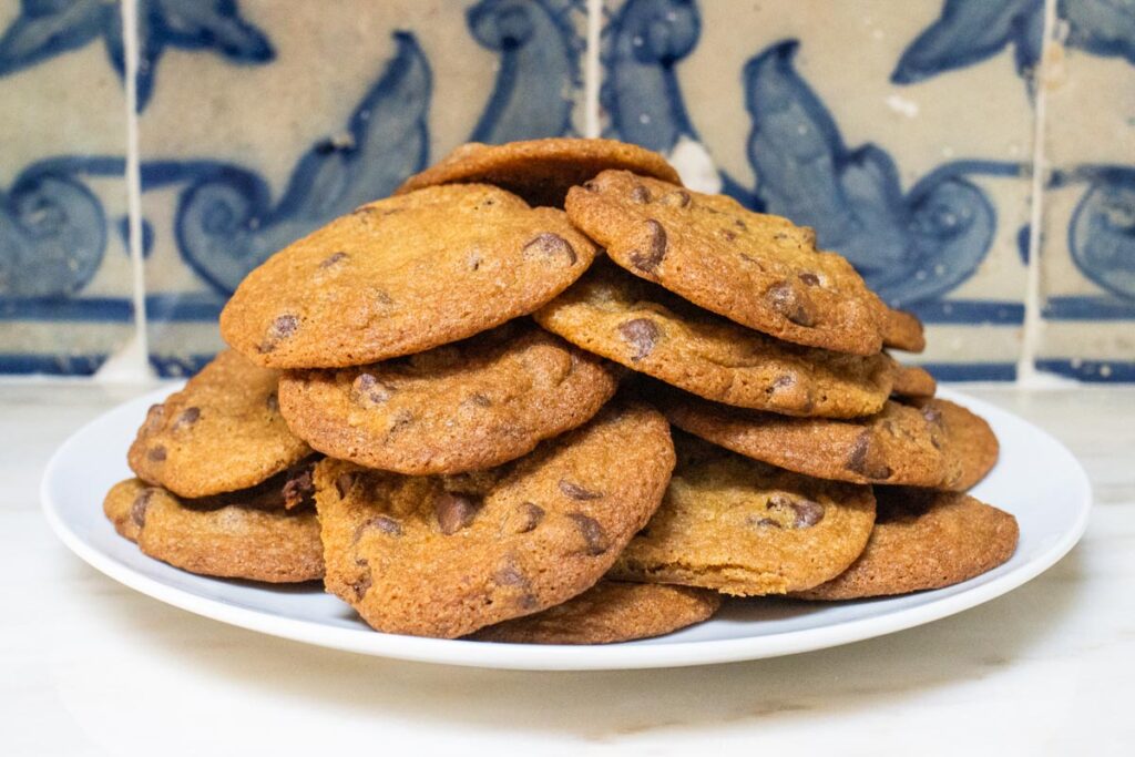 Stack of chocolate chip cookies in front of a tiled wall