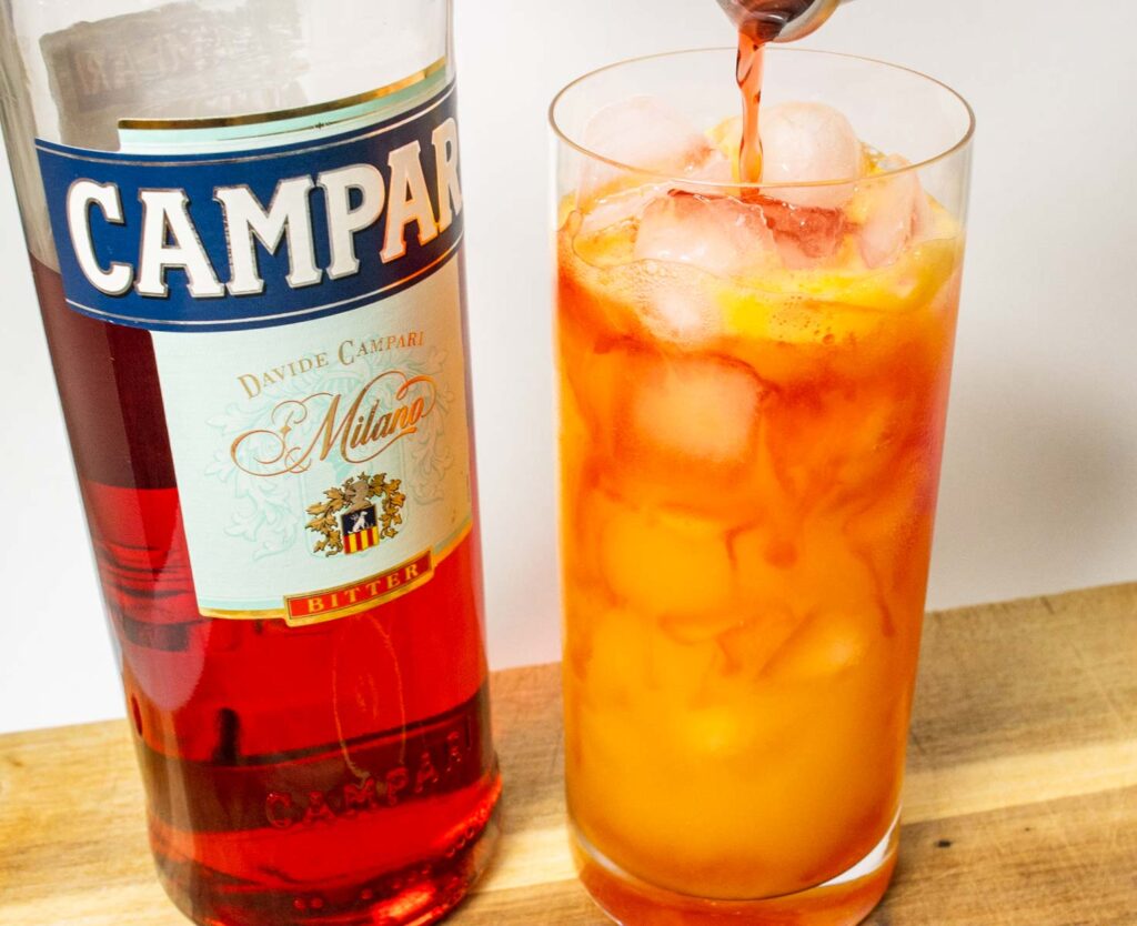Pouring Campari into a Garibaldi Cocktail