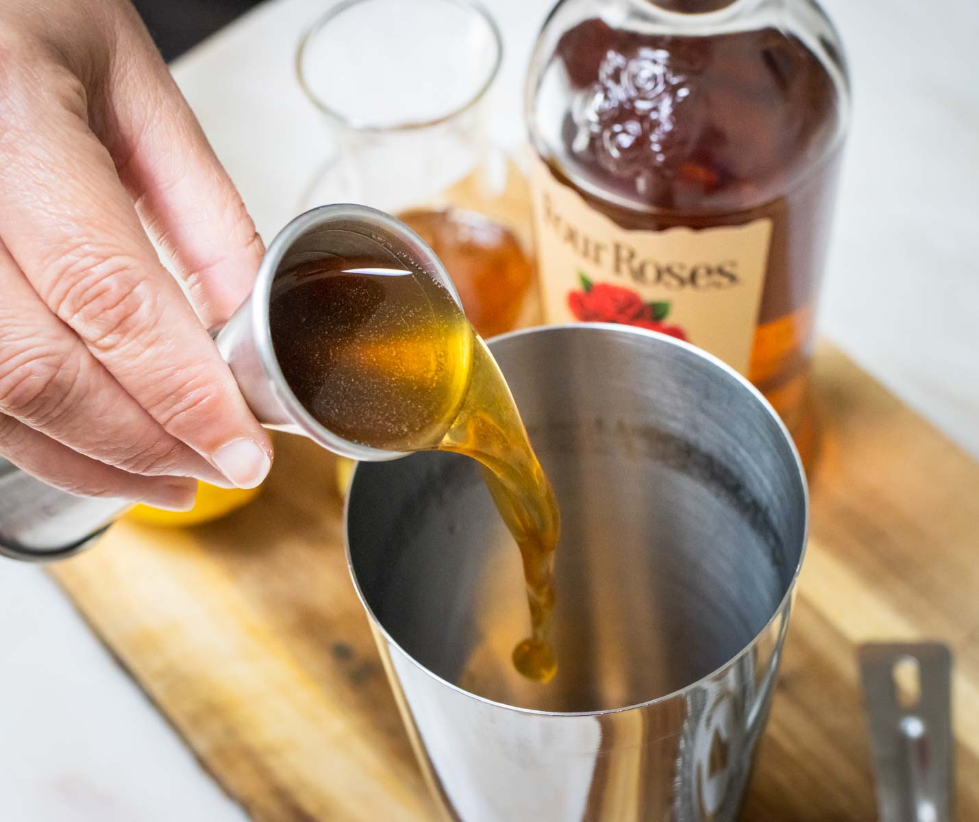 Pouring Honey Syrup into a Gold Rush Cocktail