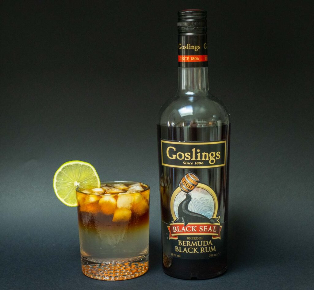 Dark and Stormy Cocktail and Gosling Rum Bottle with Black Background