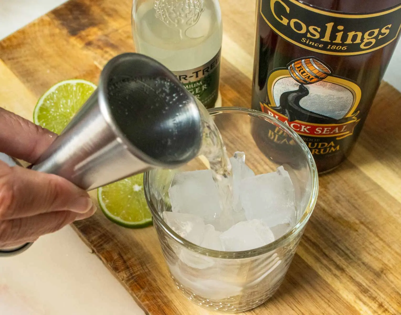 Pouring Ginger Beer into Dark and Stormy Cocktail