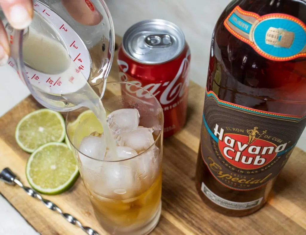 Pouring Lime Juice into Cuba Libre Recipe