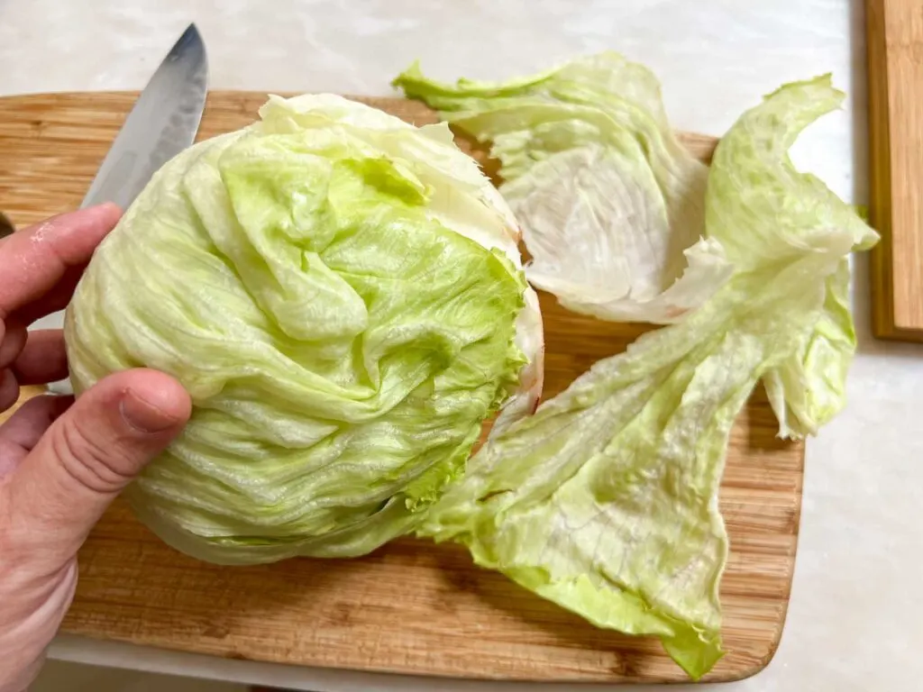 Peeling the Outer Layers of Iceberg Lettuce for Wedge Salad