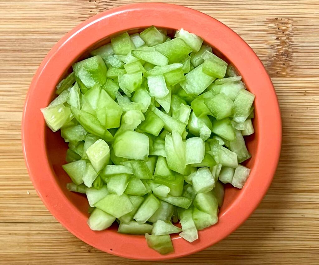 Diced cucumber in an orange prep bowl