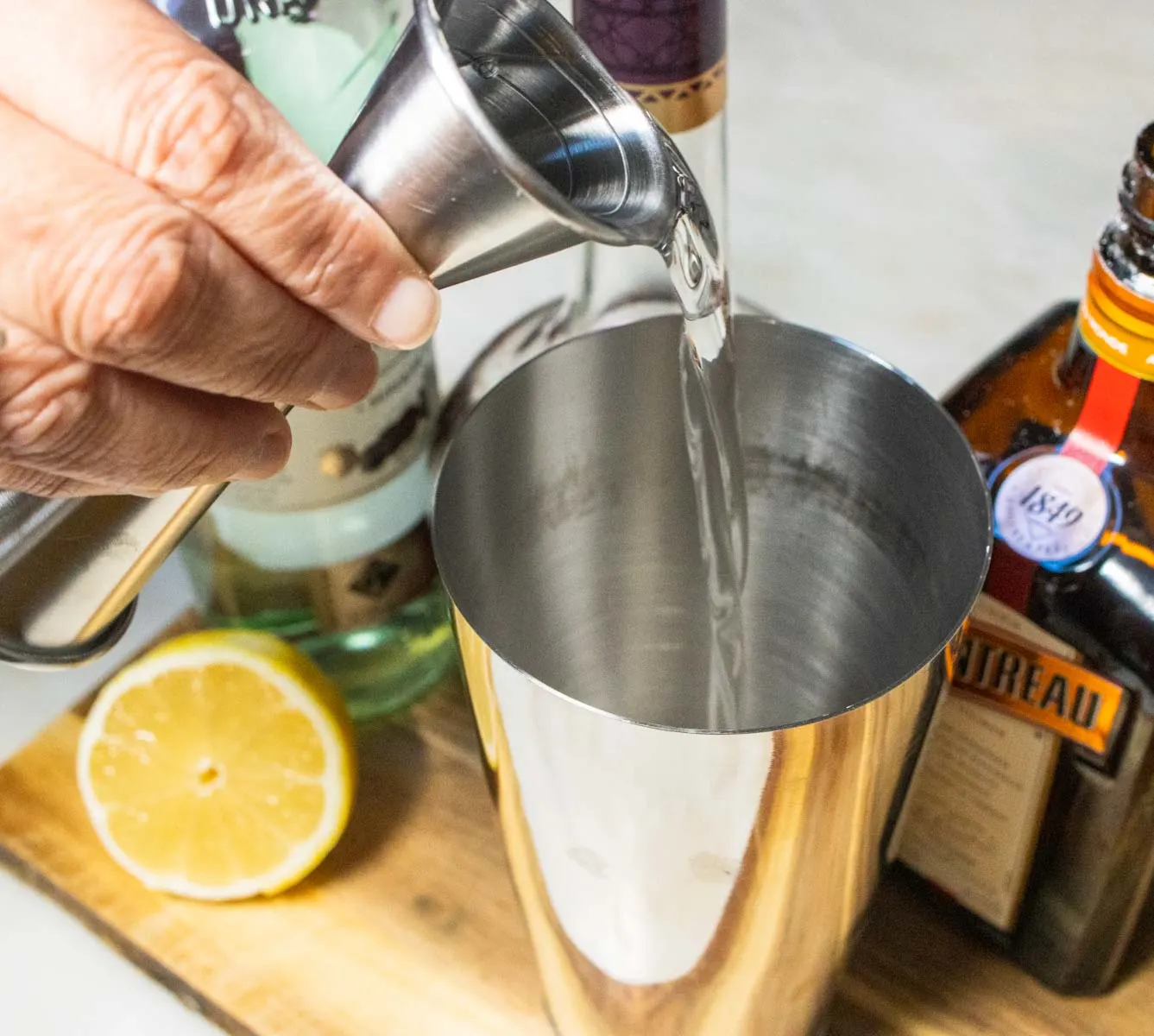 Pouring Cointreau into a Between the Sheets Cocktail