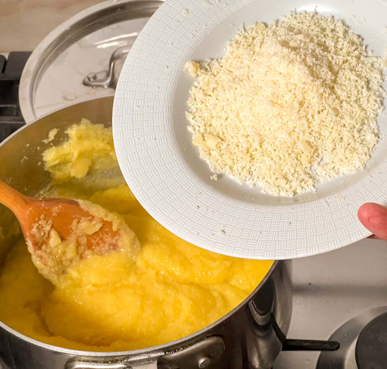 Grated grana-padano being added to finished polenta