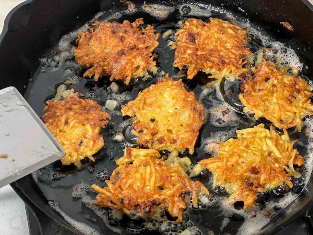 Latkes almost finished in a cast iron pan