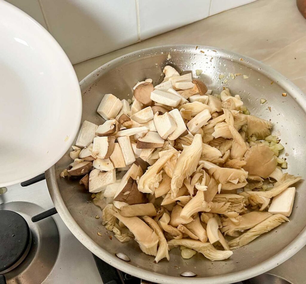 Mushrooms added to a saute pan