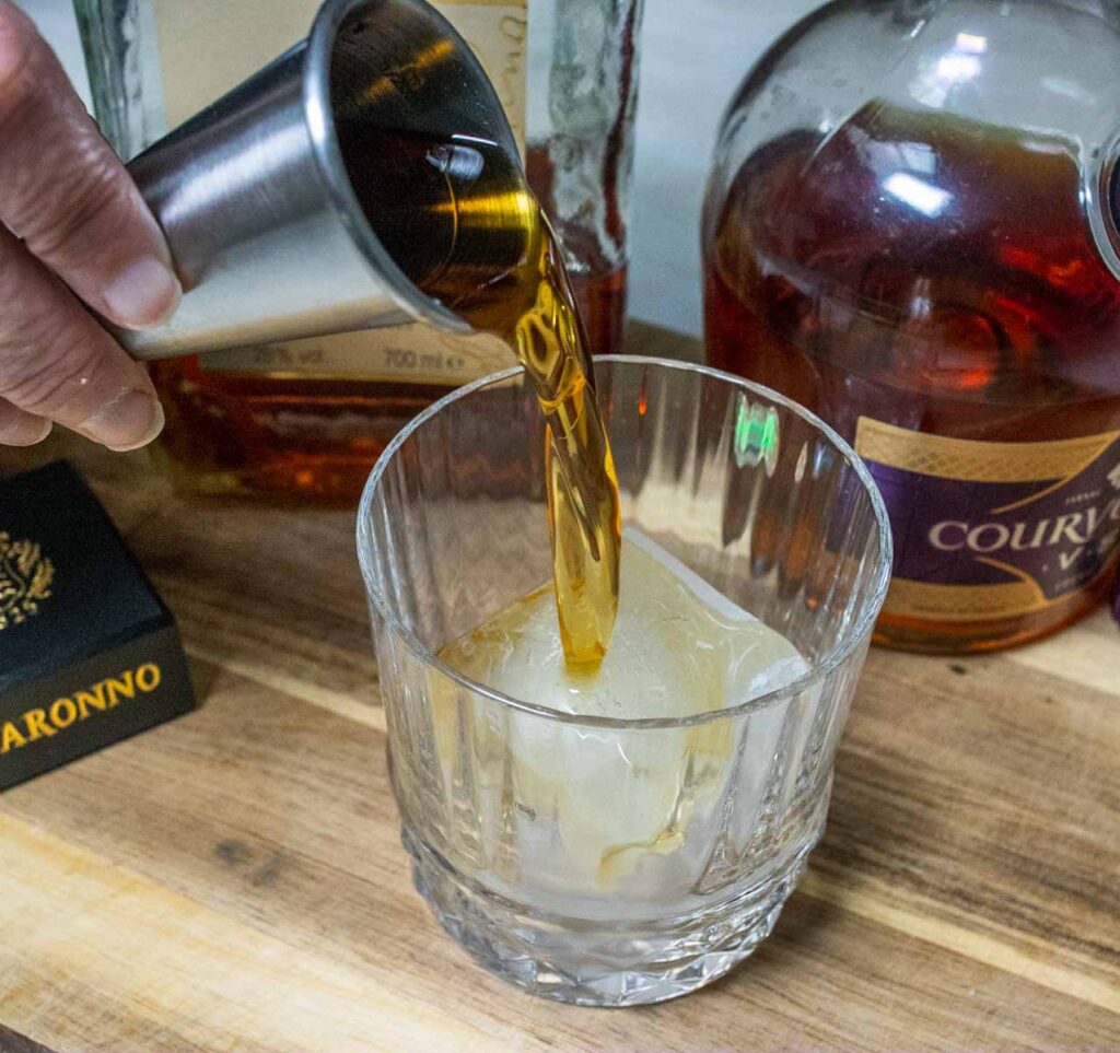 Pouring Liquor into a French Connection Cocktail