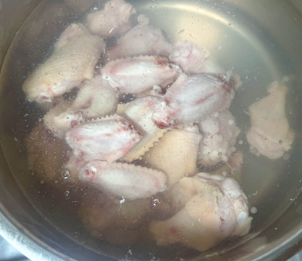 Blanching chicken wings in boiling water