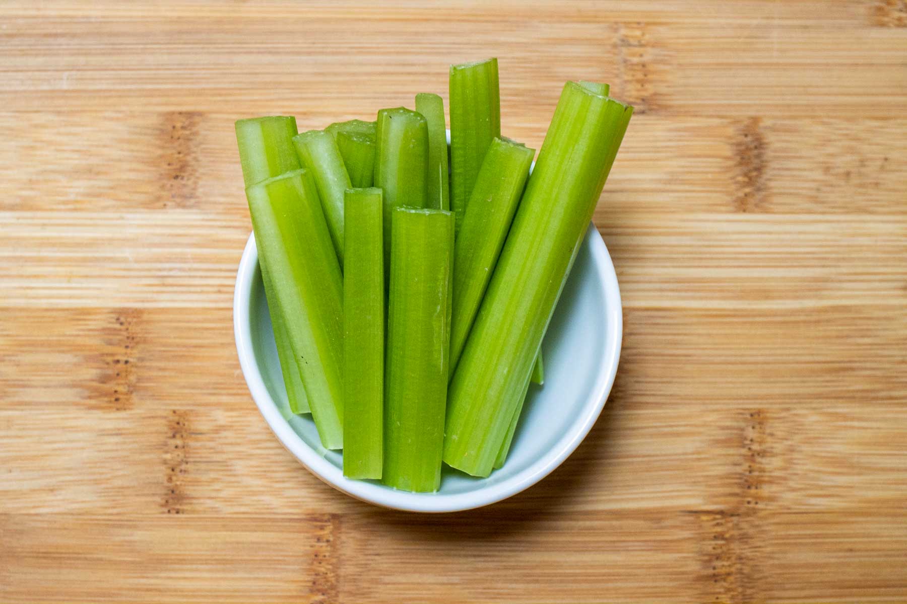 Celery sticks in a small white bowl