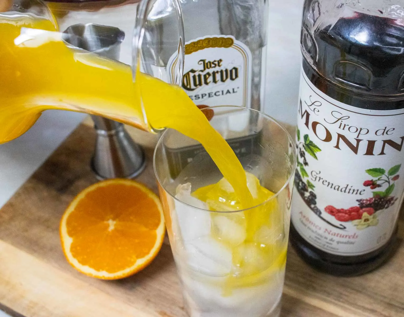 Pouring Orange Juice into a Tequila Sunrise