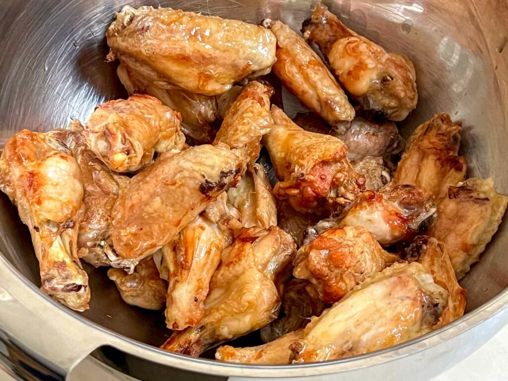 Browned Chicken Wings in a Large Mixing Bowl